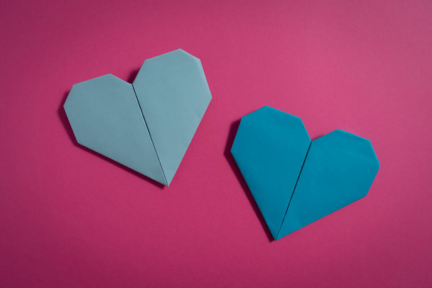 Origami hearts made with colored paper for congratulations on Valentine's Day for couples in love, on pink background. Love concept - Foto, Imagem