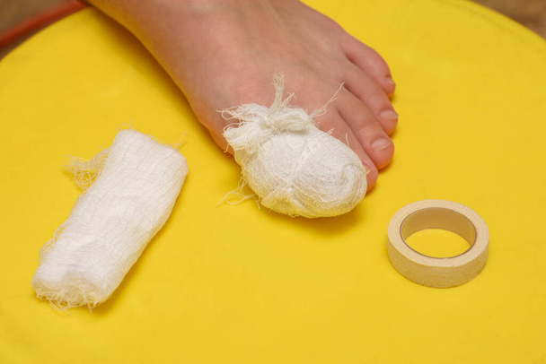Bandage your big toe, there is a bandage and an adhesive plaster nearby - Photo, Image