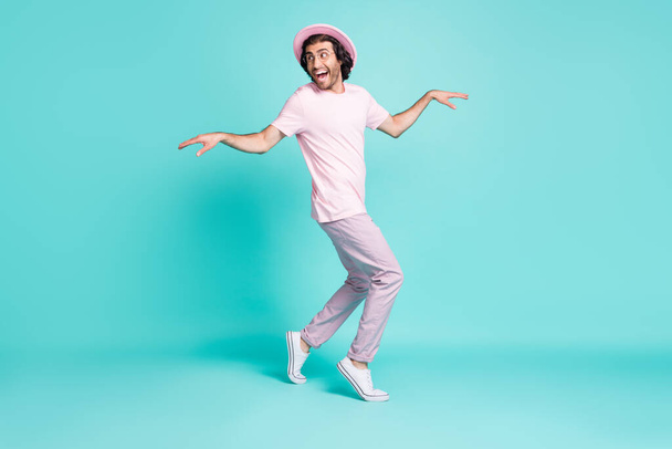 Full length profile photo of cheerful guy hush steps hiding making surprise wear spectacles cap pants t-shirt isolated teal color background - Fotoğraf, Görsel