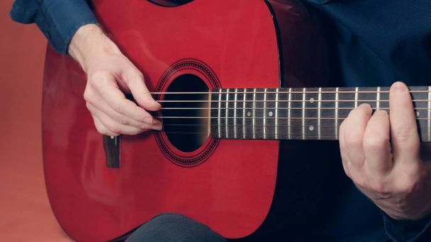 Hombre europeo toca una guitarra acústica roja - Foto, Imagen