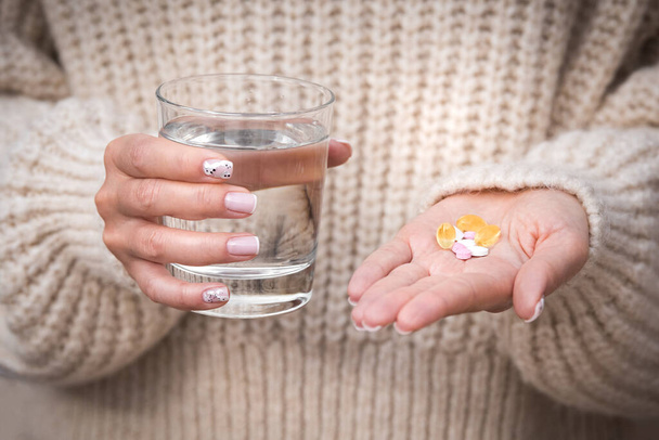 Женщина держит в руках стакан воды, витамины и добавки. B12, D3, селен. Витамины для веганов. - Фото, изображение