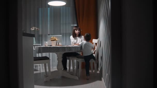 Gelukkig gezin - een kleine jongen met zijn moeder zit op de keuken - Video