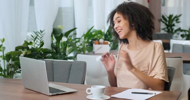 Портрет афро-американской бизнес-женщины иностранной студентки фрилансер, сидящий в кафе ресторане разговаривая в ноутбуке веб-камера использует компьютер для общения онлайн ответы видео-звонок конференц-чат - Кадры, видео