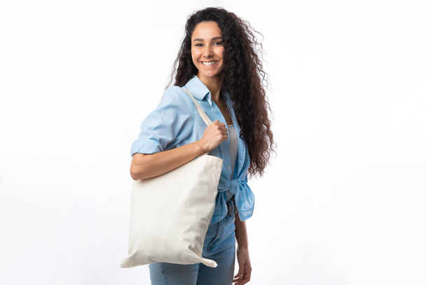 Cheerful Woman With White Eco Bag Posing Over White Background - Fotografie, Obrázek