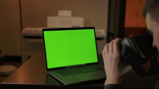 Man engineer with VR helmet programming on laptop with green screen - Footage, Video