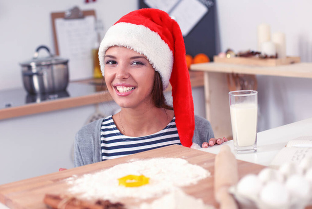 Woman making christmas cookies in the kitchen - Zdjęcie, obraz