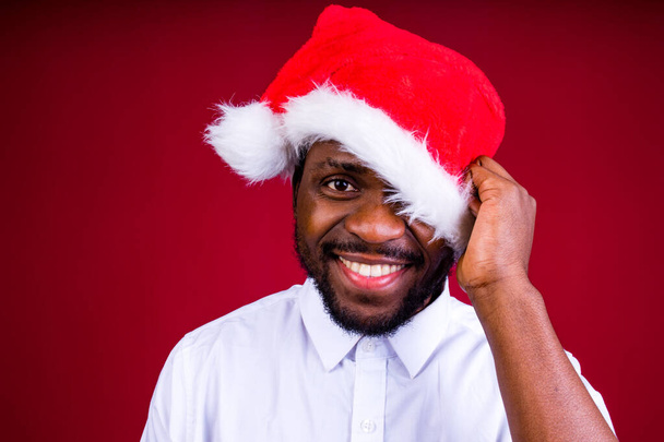 brazilian man wear santa claus headwear isolated over red color background - 写真・画像