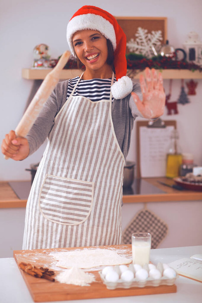 Happy young woman smiling happy having fun with Christmas preparations wearing Santa hat - Foto, immagini