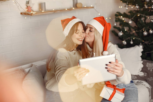 Women having fun with her friends video chat at home for Christmas - Foto, afbeelding