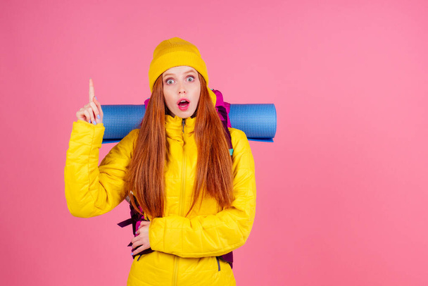 Happy woman ready for travel to mountains in new yellow jacket - 写真・画像