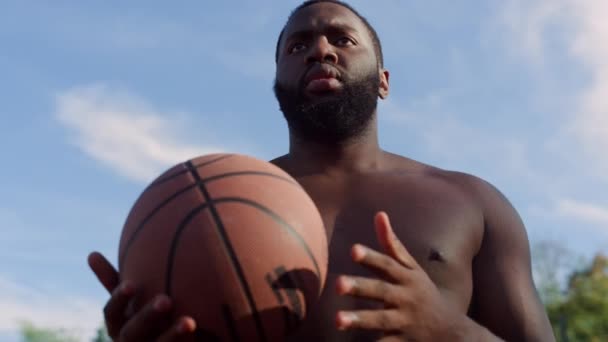 Sportif Afro-Amerikan sokak basketbolcusu dışarıda tek başına antrenman yapıyor.. - Video, Çekim