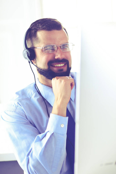 Portrait of a young man with a headset in front of a laptop computer - Foto, Imagem