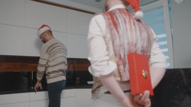 Un hombre dando un regalo sorpresa a su marido. Celebración de la víspera de Navidad y familia gay. vacaciones de invierno - Imágenes, Vídeo