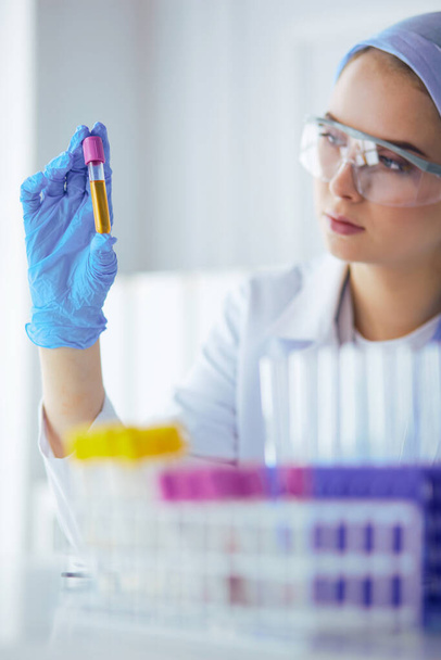 Laboratory assistant woman analyzing a blood sample - Fotó, kép