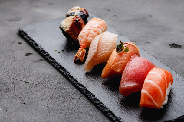 Set of nigiri sushi served on plate on grey background - Valokuva, kuva