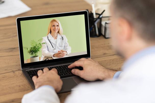 Online medisch concept. man patiënt met video conferentie met professionele arts op laptop van thuis - Foto, afbeelding