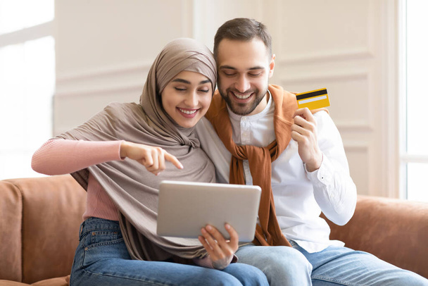 Moslim familie met behulp van digitale tablet winkelen Online zitten thuis - Foto, afbeelding