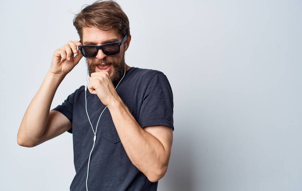 a man with sunglasses singing into an imaginary microphone music headphones fun - Foto, Imagen