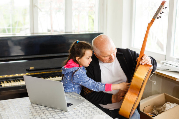 dziadek uczyć dziewczynę grać na pianinie szczęśliwie - Zdjęcie, obraz
