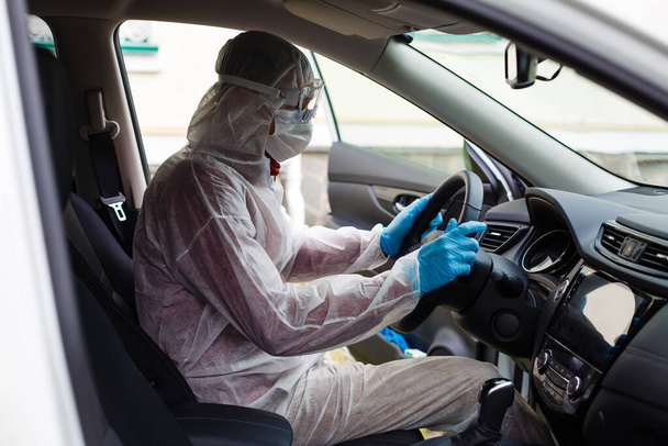 Désinfectant caractère travailleur dans un masque de protection et pulvérisation de costume bactérien ou virus dans une voiture. - Photo, image