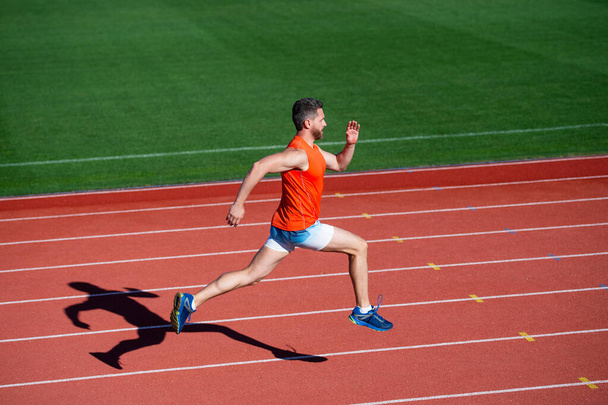 sportsman man in sportswear run fast sprinting on running track, energy - Foto, Bild