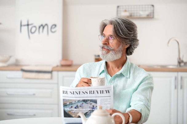 Senior mit Tasse Kaffee und Zeitung zu Hause - Foto, Bild
