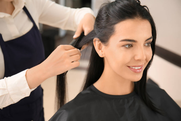 Friseurin richtet Frau im Salon die Haare - Foto, Bild
