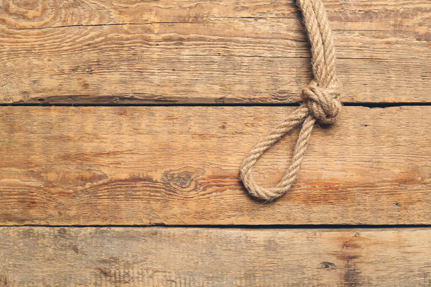 Rope with knot on wooden background - Photo, Image