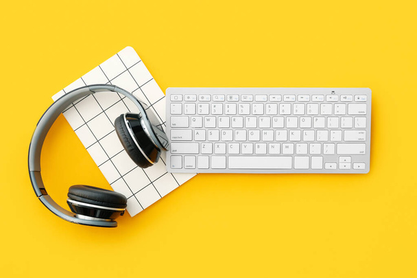 Комп'ютерна клавіатура, ноутбук і навушники на кольоровому фоні
 - Фото, зображення