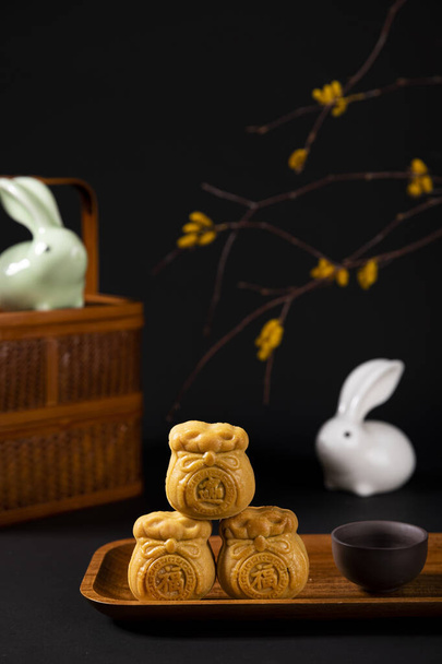 A vertical shot of mooncakes on a plate for Mid-Autumn Festival isolated on black background - Foto, afbeelding