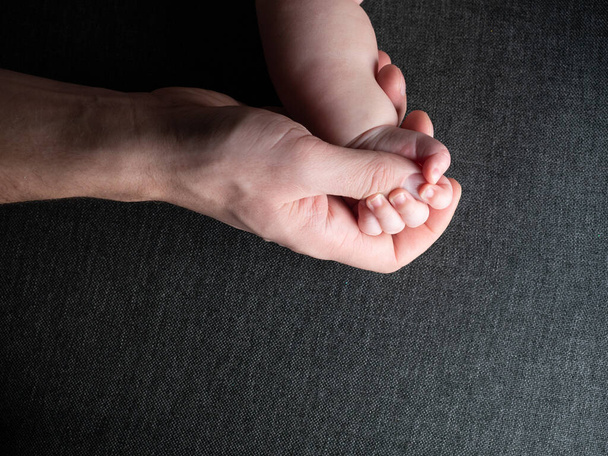 Closeup of father holding baby hand fathers day - Foto, imagen