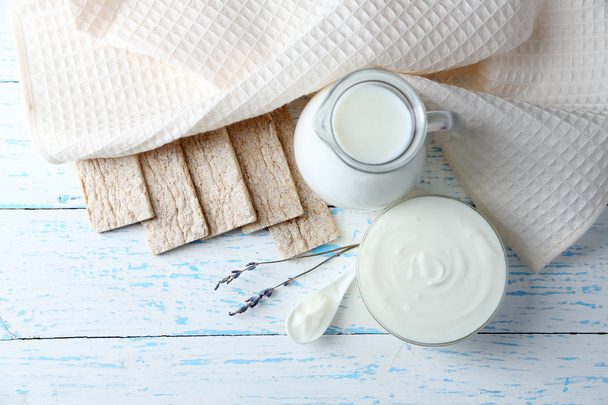 Homemade yogurt and tasty Tasty crispbread on wooden table background - Photo, image