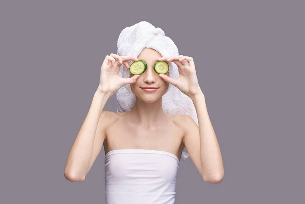 Cosmetology concept. Skin care product. Female portrait. Cucumber face mask. - Fotó, kép