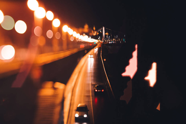 samochody jadące nocą po mieście wzdłuż rzeki w Budapeszcie - Zdjęcie, obraz