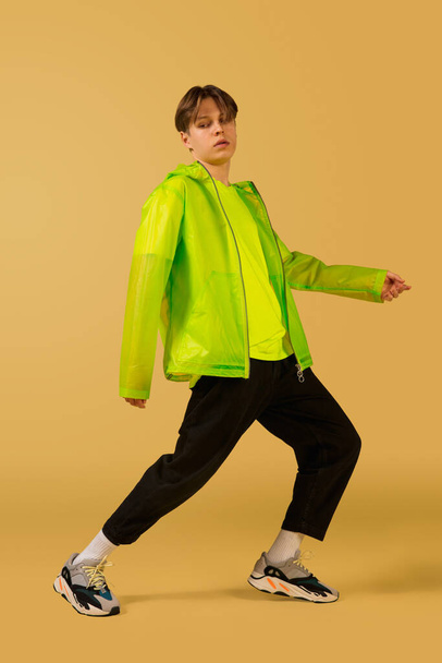 Old-school fashioned young man dancing isolated on yellow background - Valokuva, kuva