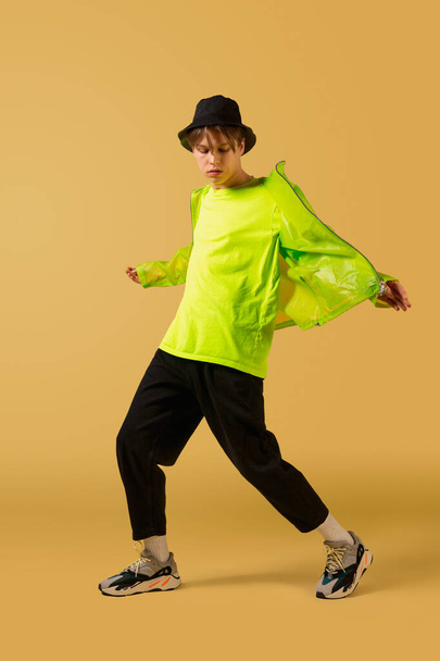 Old-school fashioned young man dancing isolated on yellow background - Фото, зображення