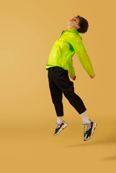 Old-school fashioned young man dancing isolated on yellow background - Foto, Imagem