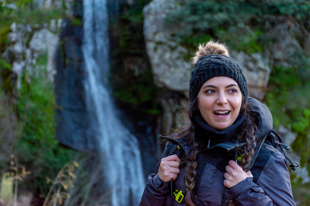 Mladá, krásná bílá běloška v usměvavé zimní čepici s vodopádem - Fotografie, Obrázek