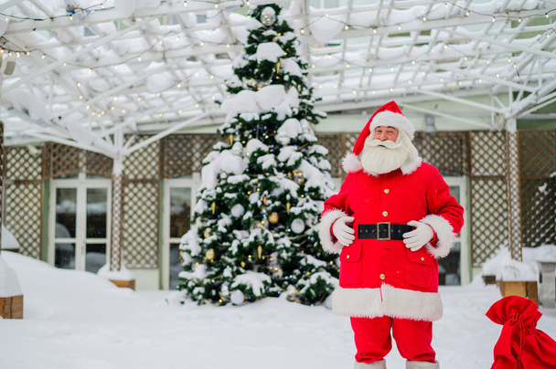 Santa claus wishes a merry christmas outdoors - Foto, Imagen