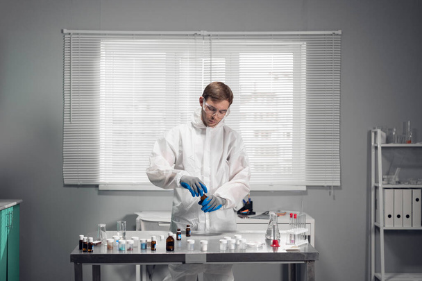 Uno scienziato maschio sta testando una sostanza chimica in un laboratorio scientifico. Concetto di laboratorio scientifico - Foto, immagini