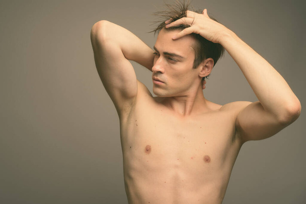 Estúdio tiro de jovem bonito homem sem camisa contra fundo cinza - Foto, Imagem