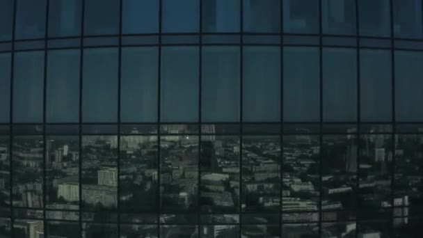 Gökdelen cam cephesinin havadan görünüşü ve şehrin üzerinde parlayan parlak güneş ışığı. Stok görüntüsü. Uluslararası iş merkezi boyunca uçuyor. Ofisleri pencerelerin arkasında.. - Video, Çekim