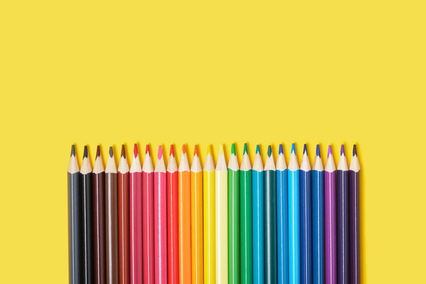 color pencils on yellow background top view copy space - Photo, Image