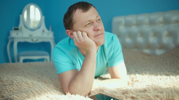 Uomo attraente sognando mentre sdraiato sul letto la mattina presto - Filmati, video