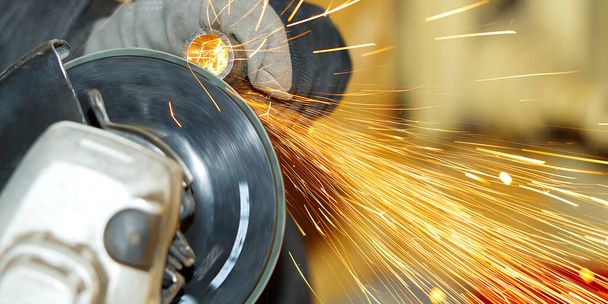 worker makes metal steel pipe grinding, close-up many sparks - Photo, Image