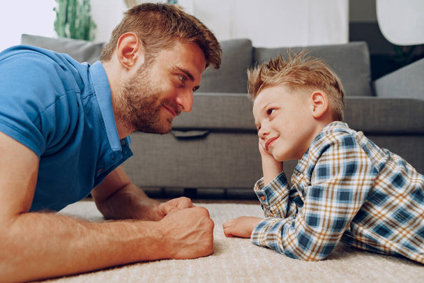 Father and son playing together on carpet at home - Photo, Image