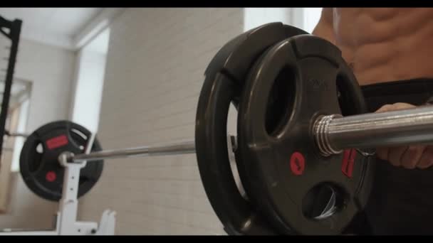 Νεαρός bodybuilder κάνει πάτημα πάγκου με ένα κουδούνι στην εκπαίδευση στο γυμναστήριο και κουνάει τους θωρακικούς μυς και τρίφτες - Πλάνα, βίντεο