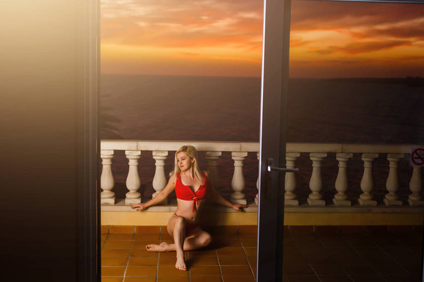 vrouw bewonderen zonsondergang vanaf haar balkon - Foto, afbeelding