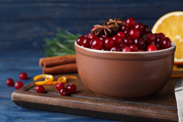 Fresh ripe cranberries and spices on blue wooden table - Fotografie, Obrázek