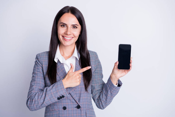 Photo of attractive business lady hold telephone gadget device app directing finger sensor screen amazing new interface quality formalwear plaid suit isolated grey color background - 写真・画像